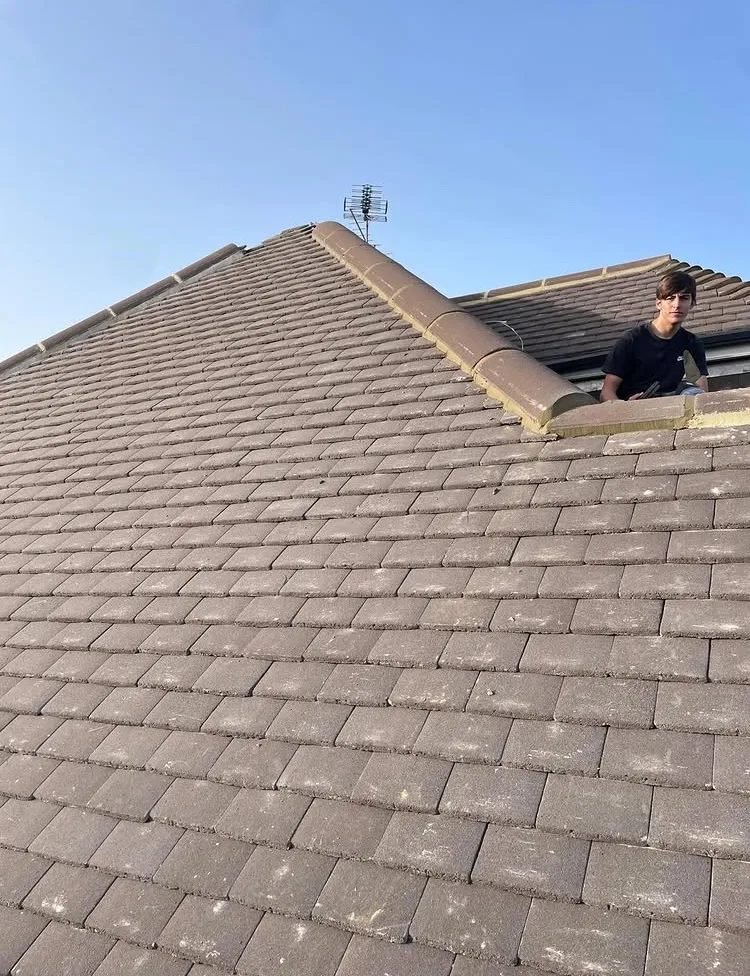 Ridge line work on grey tiled roof